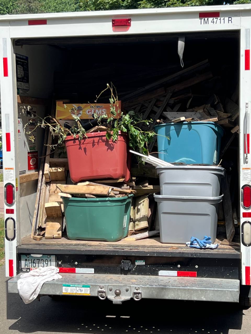 Truck fully loaded with storage bins, scrap wood, and yard waste